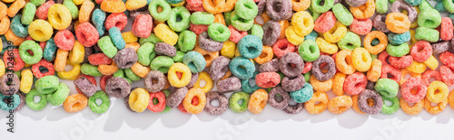 Photo top view of bright multicolored breakfast cereal on white background, panoramic