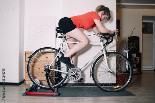 Cardio home workout on the cycle trainer by beautiful female
