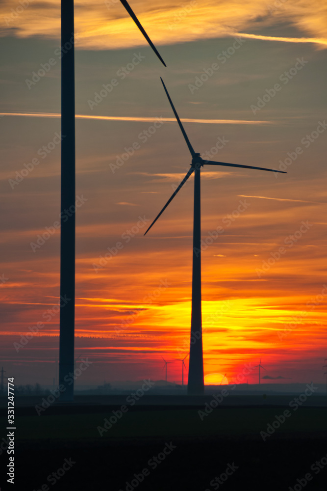 Windkraftanlage im Abendrot bei Sonnenuntergang im Marchfeld Niederösterreich, a wind turbine in deep red afterglow Windkraftanlage im Abendrot bei Sonnenuntergang im Marchfeld Niederösterreich, a wind turbine in deep red afterglow