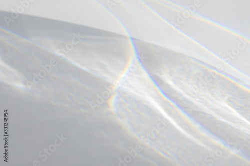 Water texture overlay effect for photo and mockups. Organic drop diagonal shadow caustic effect with rainbow refraction of light on a white wall.