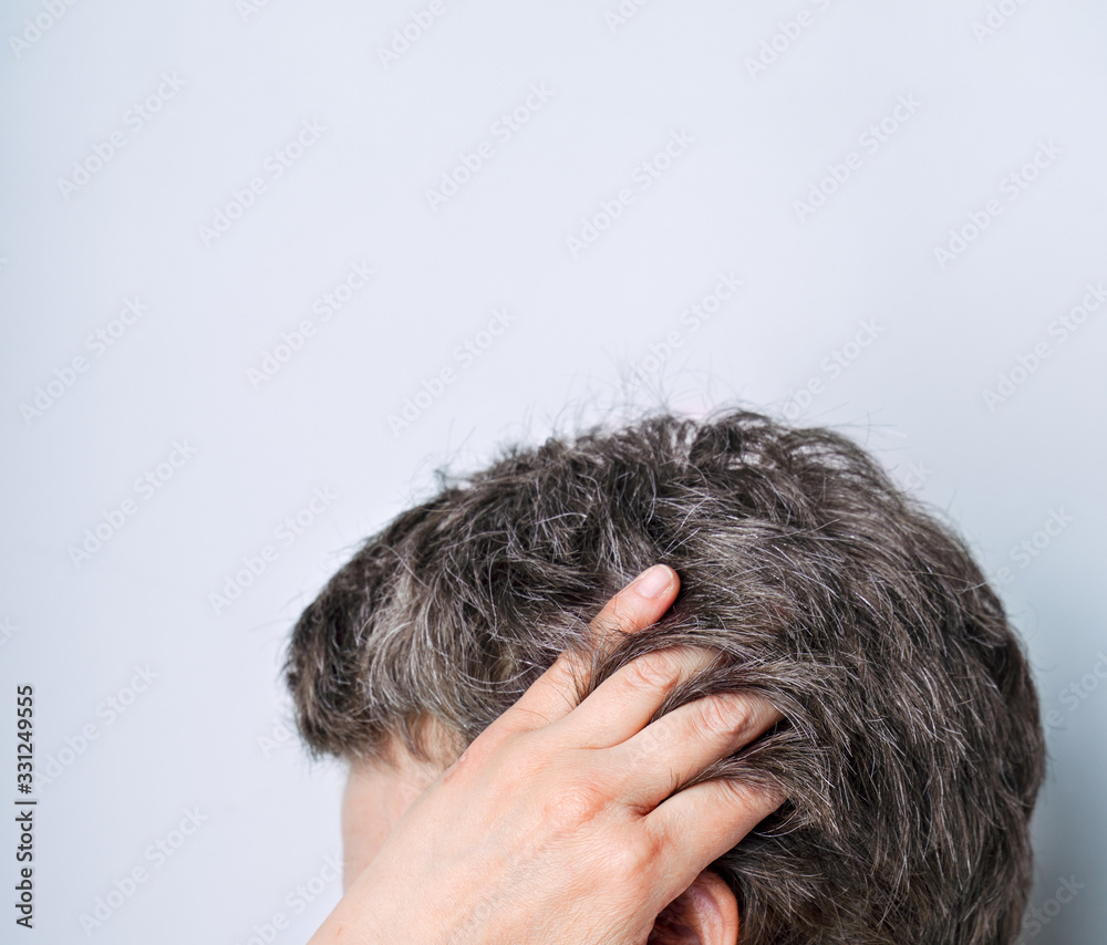 Fototapeta premium Woman of 40-50 showing naturally gray hair on light gray background. Natural ageing and diversity concept
