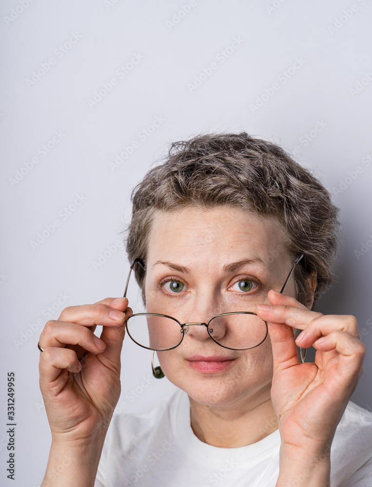 Headshot of a candid looking gray haired woman 40-50 with glasses Headshot of a candid looking gray haired woman 40-50 with glasses