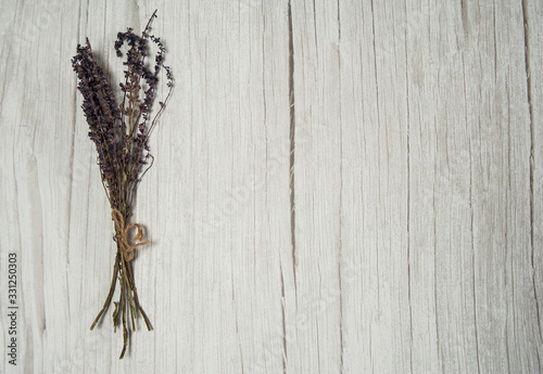 Phytotherapy. Composition of dry herbs for herbal medicine. A bunch of dry sage grass (Salvia officinalis) on a light wooden background. Free space. © Valentina