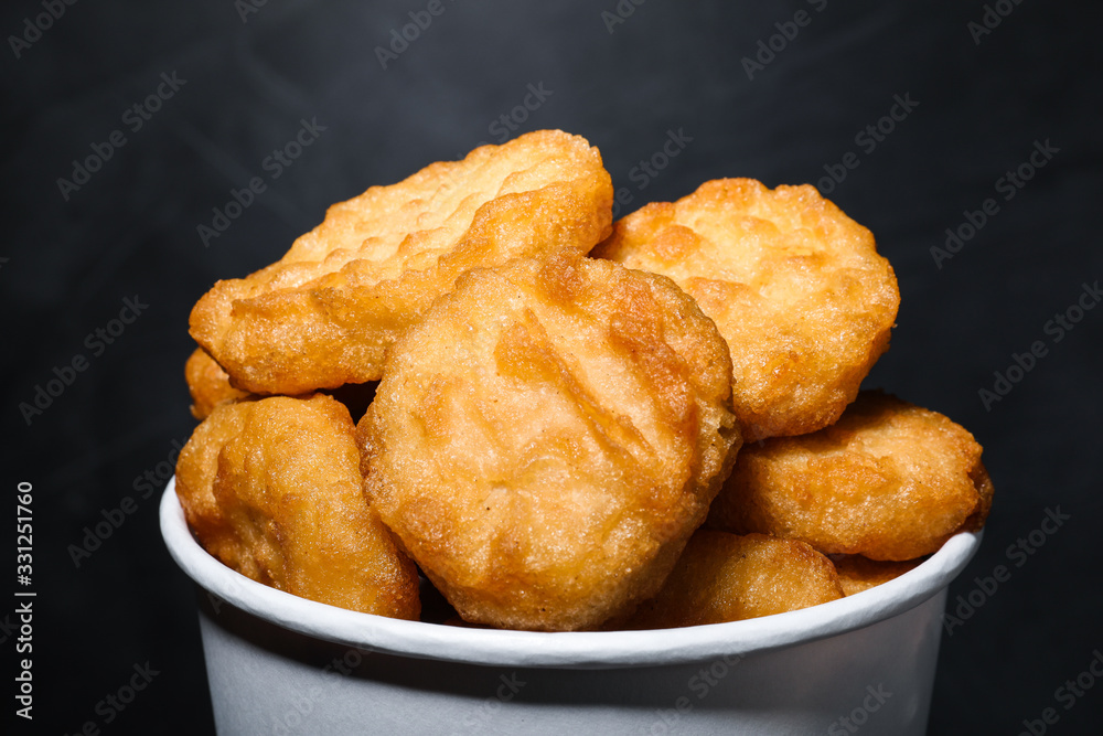 Bucket with delicious chicken nuggets on grey background, closeup Bucket with delicious chicken nuggets on grey background, closeup