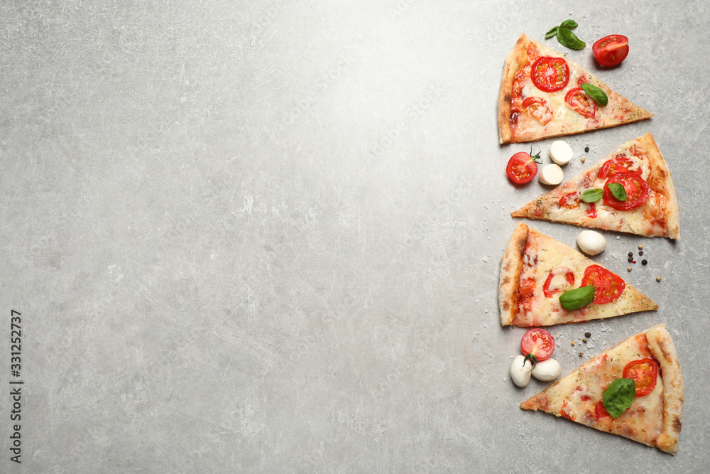 Slices of delicious pizza Margherita on light grey table, flat lay. Space for text Slices of delicious pizza Margherita on light grey table, flat lay. Space for text