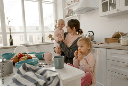 A young mother spends time with her little daughters at home.