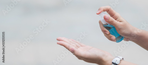 woman hand spraying hand alcohol sanitizer bottle dispenser, against Novel coronavirus or Corona Virus Disease (Covid-19) at public outdoor. Antiseptic, Hygiene and Healthcare concept