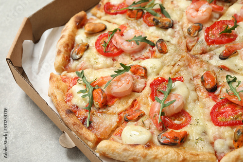Delicious seafood pizza in box on table, closeup