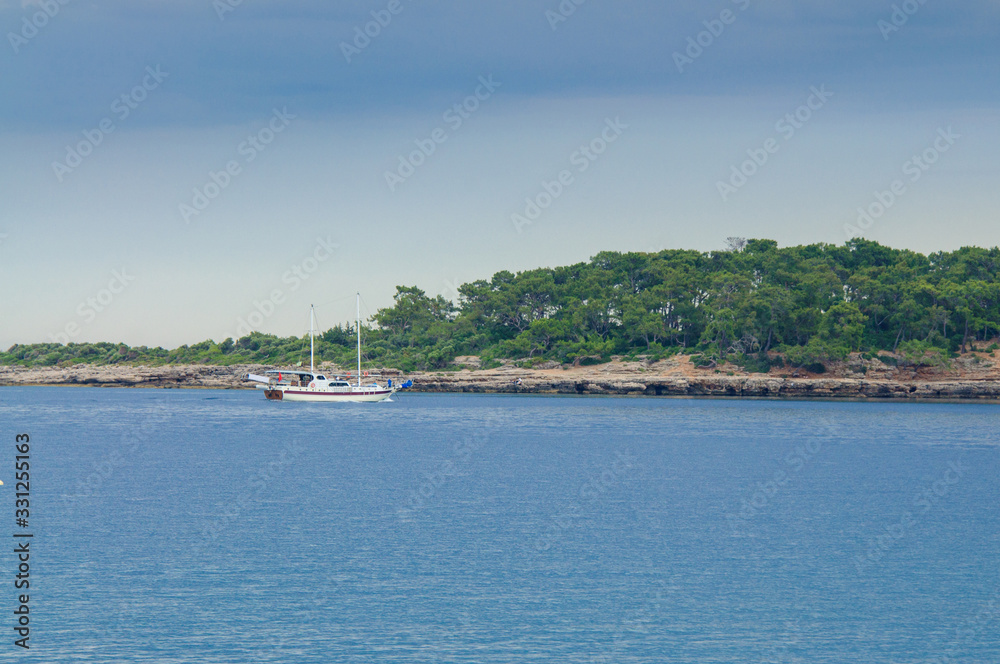  Pleasure yacht against a stone coast