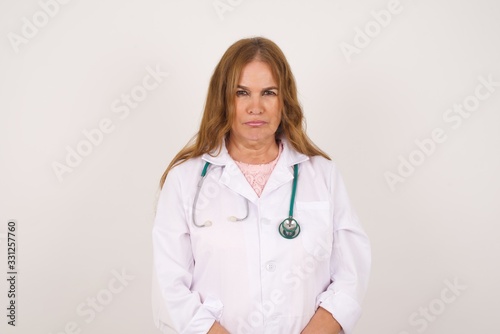 Sad doctor woman crying desperate and depressed with tears on her eyes suffering pain and depression isolated on grey background. Facial expression and emotion concept.