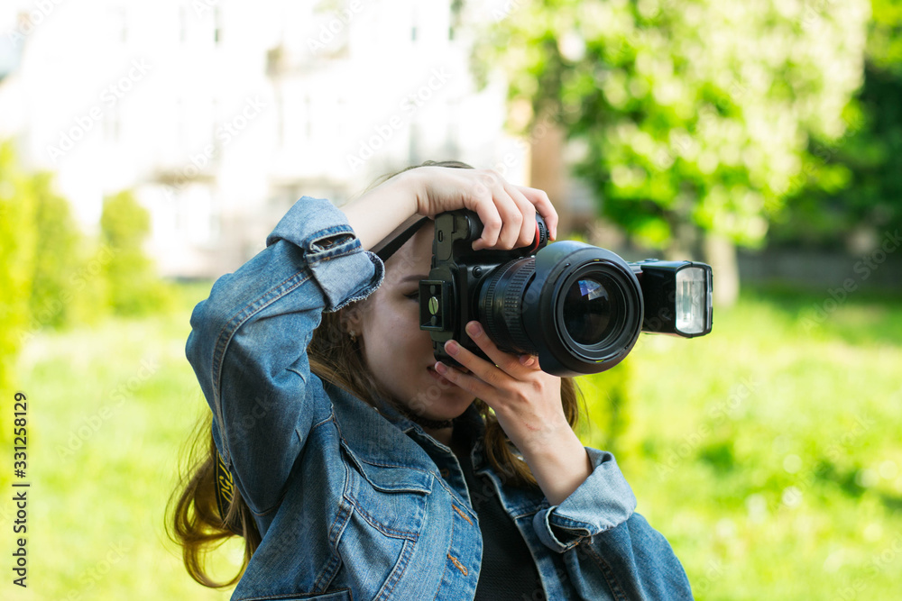 Woman is a professional photographer with dslr camera, outdoor and sunlight, Portrait, close up.