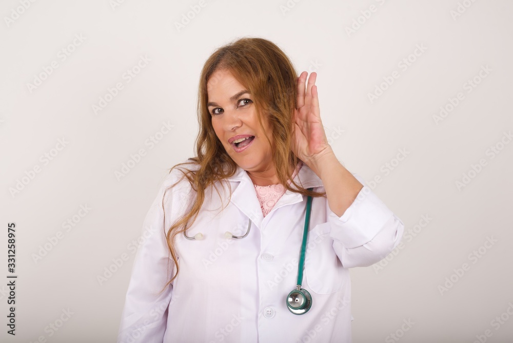 Oh my God! Funny astonished European doctor female opening mouth widely, raising eyebrows and popping eyes out in surprise with hand near ear trying to listen to gossips. Oh my God! Funny astonished European doctor female opening mouth widely, raising eyebrows and popping eyes out in surprise with hand near ear trying to listen to gossips.