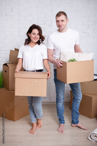 moving day concept - happy couple packing moving cardboard boxes © Di Studio