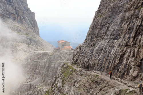 Alpine hut Rifugio Pedrotti and mountain alps panorama in Brenta Dolomites, Italy photo