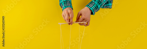controling your mind, twisted sticks with ropes in the hand, puppet concept, isolated wide web banner