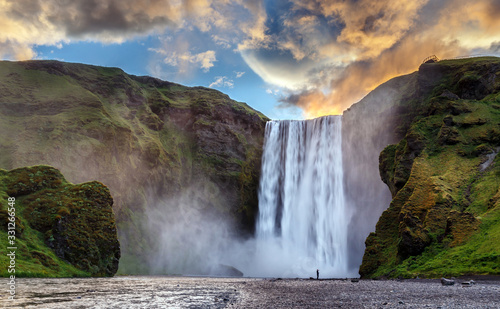 Majestic nature of Iceland. Impressively View on Skogafoss Waterfall with colorful sky glowing sunlight  during sunrise. Skogafoss the most famous place of Iceland. creative artistic image. postcard