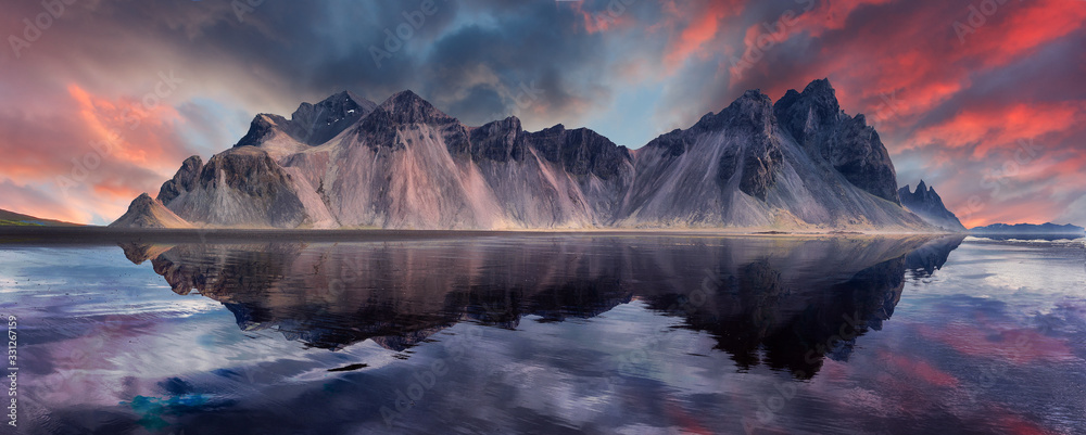 Fototapeta Vestrahorn mountaine on Stokksnes cape in Iceland during sunset with reflections. Amazing Iceland nature seascape. popular tourist attraction. Best famouse travel locations. Scenic Image of Iceland