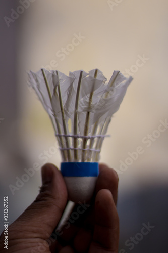 White Shuttlecock in a hand. Activity outdoor  in the evening life style. Exercise equipment background