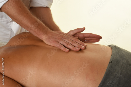 Masseur doing massage on woman body in the spa salon 