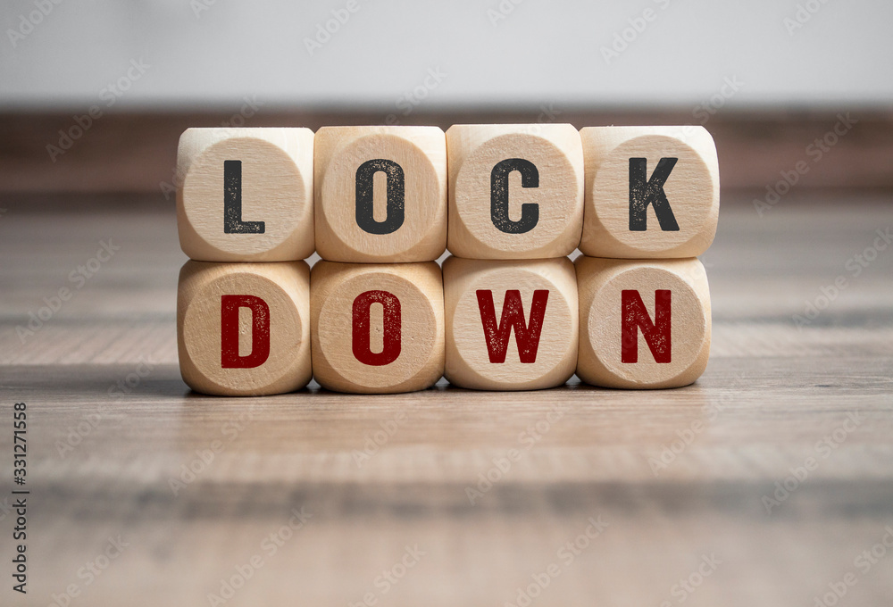 Cubes and dice with word shutdown and lockdown on wooden background