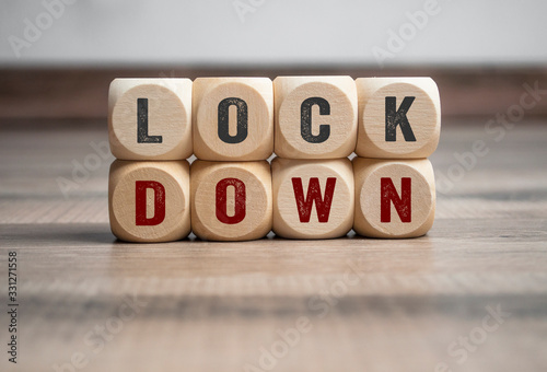 Cubes and dice with word shutdown and lockdown on wooden background photo