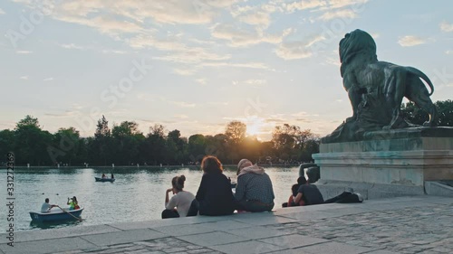 4K Madrid, Retiro Park, people sitting during sunset, flare