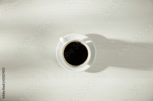 fresh coffee on wooden table and top view.morning time and sun light. 