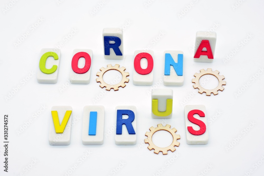 La palabra coronavirus hecha con fichas de dominó y letras de madera, unas levantadas y otras tumbadas sobre fondo blanco