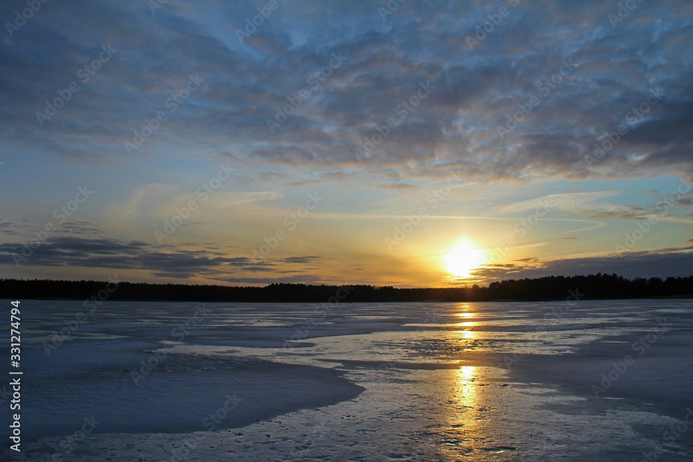 Winter landscape with beautiful frozen lake at sunset.