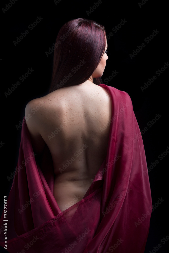 Portrait of woman with bare back on black background