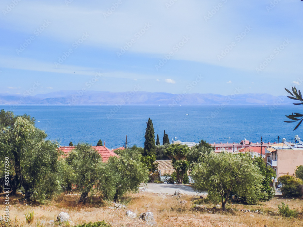 Fototapeta premium Greece, Corfu island. A beach with crystal clear azure water and a white beach in picturesque landscapes - the paradise coastline of the island of Corfu in Paleokastritsa, Ionian archipelago