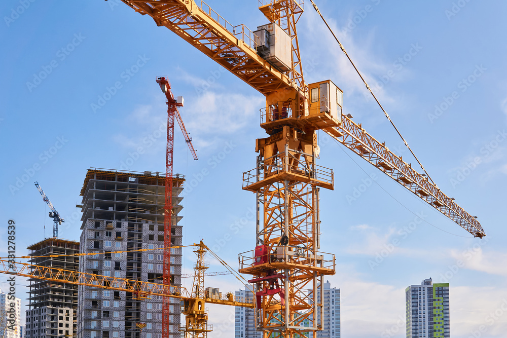 construction tower cranes on a building site against the sky