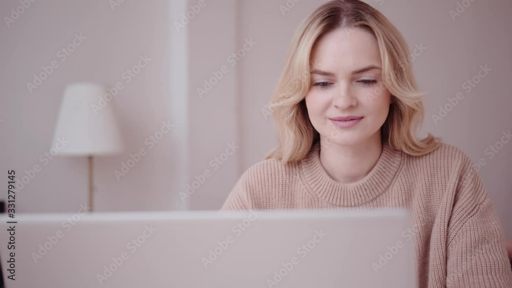 Beautiful pleasant woman opens a laptop and starts work Beautiful pleasant woman opens a laptop and starts work