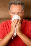 Man with the Flu Sneezing into a Handkerchief at his House