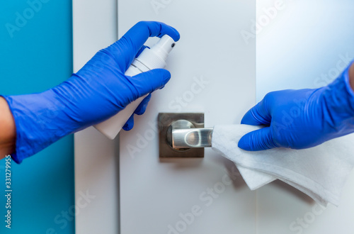 Cuadro en lienzo Decontaminating the surface of the door handle