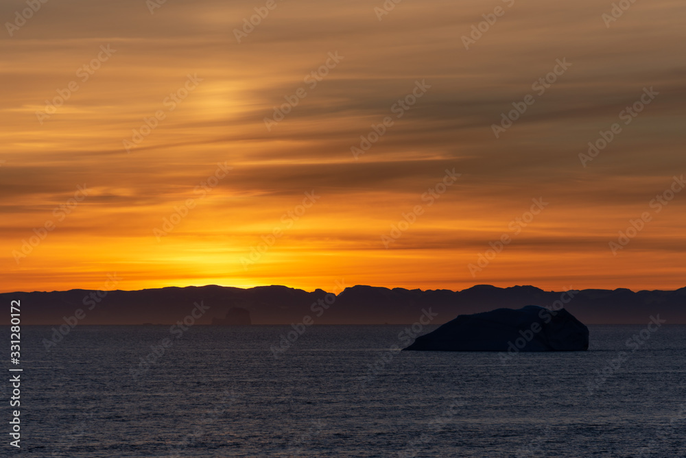 Beautiful sinrise in Greenland. Iceberg at sea.