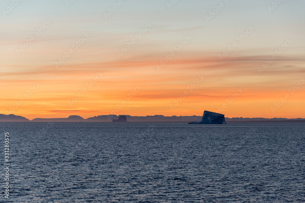 Beautiful sinrise in Greenland. Iceberg at sea.