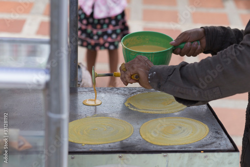 Seller cooking at a Cambodian pancake stand on the streets of Kratie in Cambodia