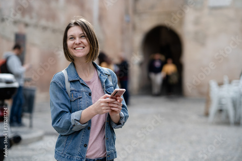 Young woman on the street holding a phone
