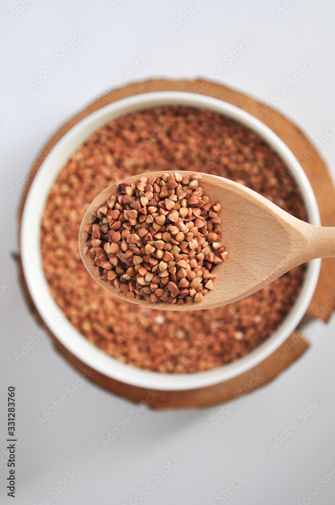 buckwheat on a plate and spoon isolated background buckwheat on a plate and spoon isolated background