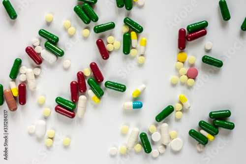 pills and capsules on white table surface photo