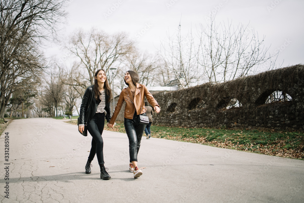 Fototapeta premium Two happy girls walking on the street