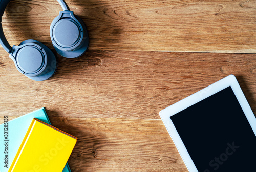 Composition of digital tablet notebooks headphones and coffee on a desk with wooden background photo