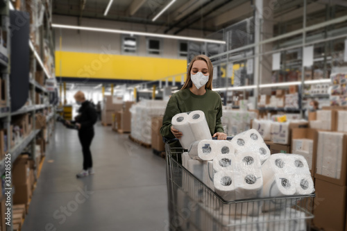 Toilet paper shortages amid panic throughout the world due to the influenza epidemic and the COVID-19 coronavirus pandemic. Woman in a store buys toilet paper. People, social problems, quarantine