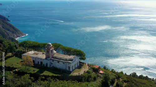 Amazing aerial shot over the church in the village of Riomaggiore, one of the Cinque Terre in La Spezia, Italy. Drone flight and aerial view - travel concept