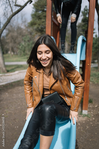 Pretty girl going down on a slide in park