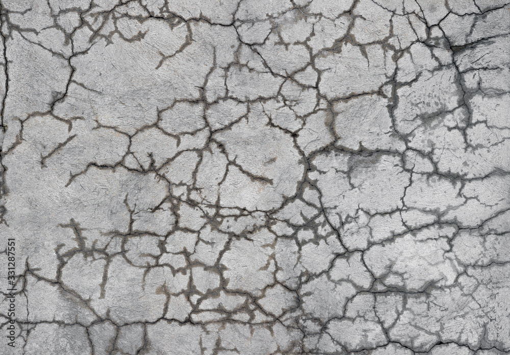 A gray concrete wall with curly cracks that show moisture. Background A gray concrete wall with curly cracks that show moisture. Background