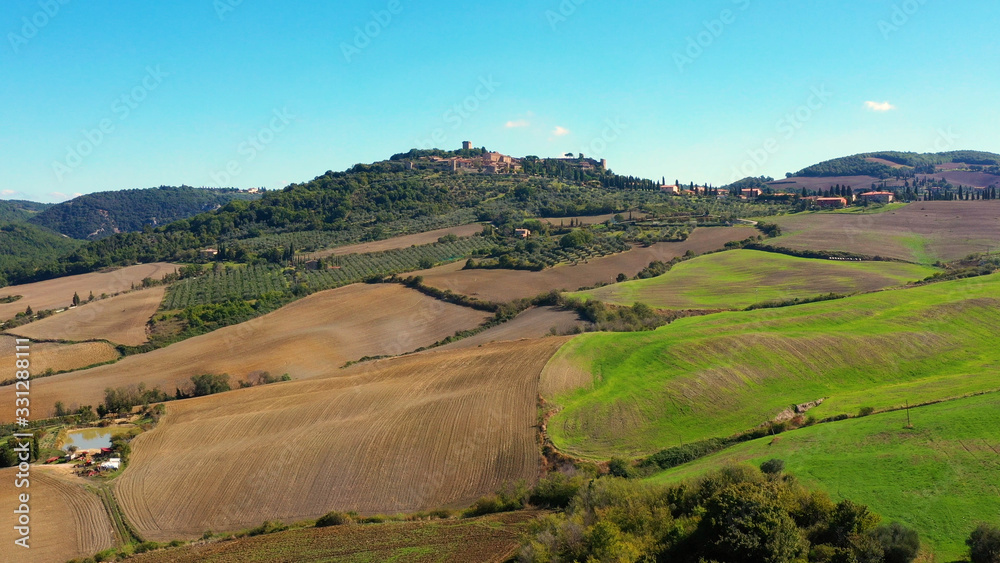 Fototapeta premium Italian village of Monticchiello in Tuscany, Italy. Drone flying over the magnificent village and green meadows. Perfect for authentic travelling in Italy 