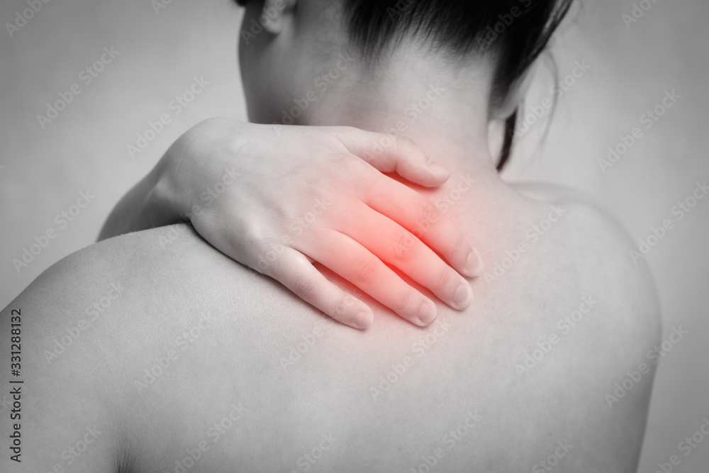 the woman massages the shoulder with her hand. the view from the back. isolated on white background the woman massages the shoulder with her hand. the view from the back. isolated on white background