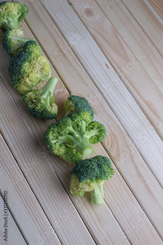 green healthy broccoli on light wood